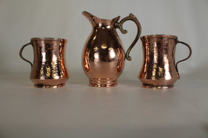A Copper Creamer and Hand Hammered Copper Mugs